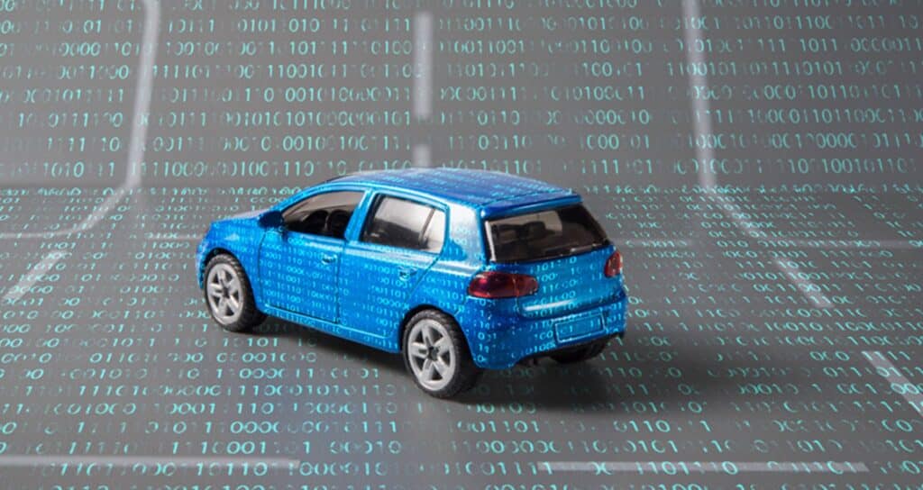 A blue car on a backdrop covered with 1s and 0s