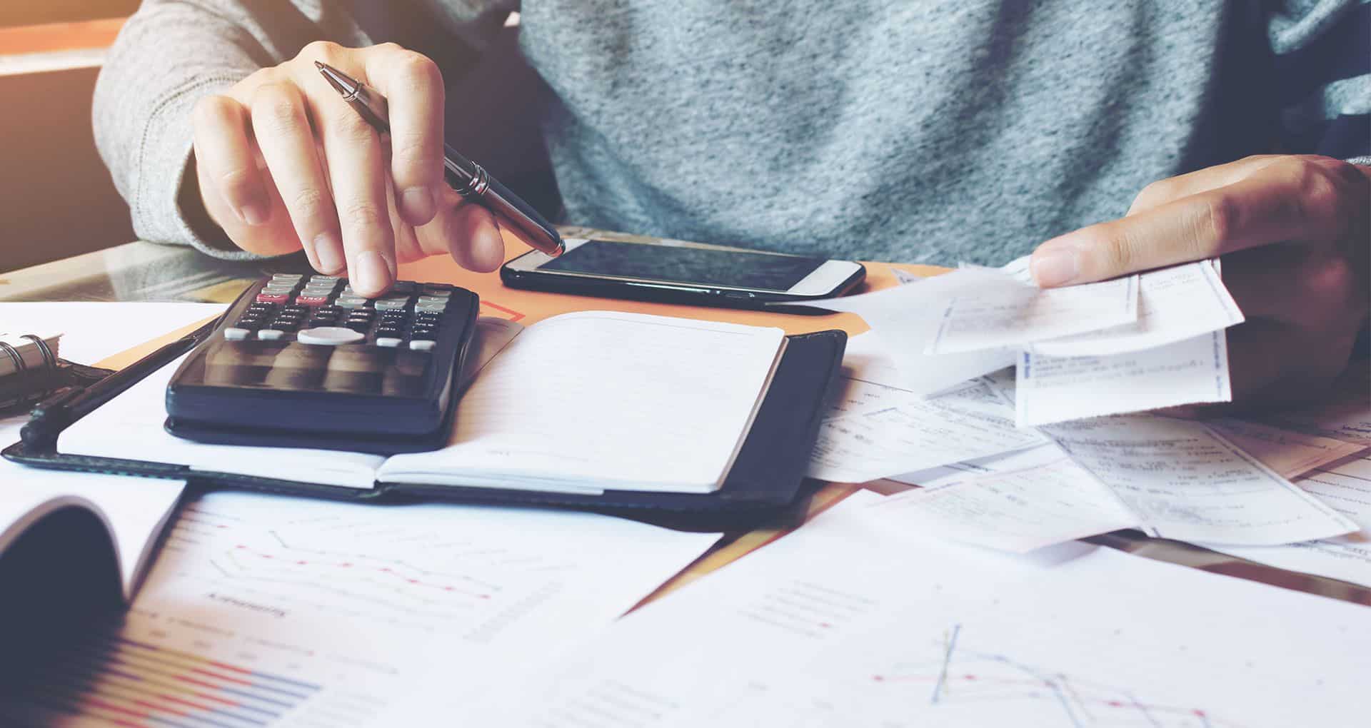 A woman doing taxes with a calculator and a notepad