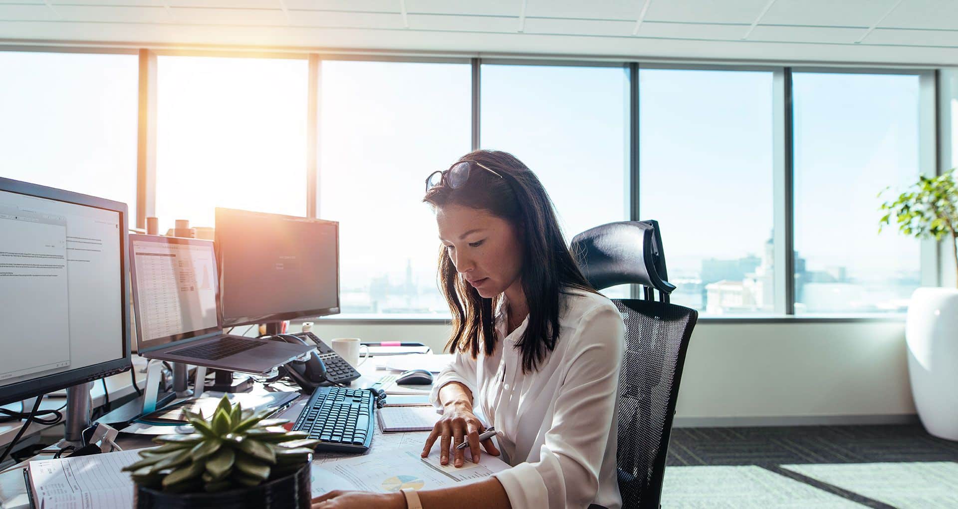 A woman in an office looking at graphs and charts