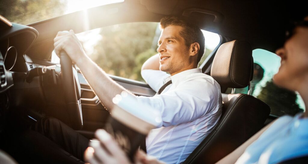 A man driving in a car having a conversation with a woman in the passenger's seat
